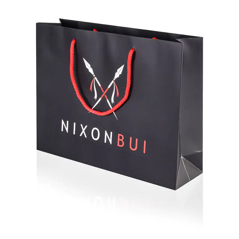 Matt laminated black paper bag with red rope handle that says nixonbui