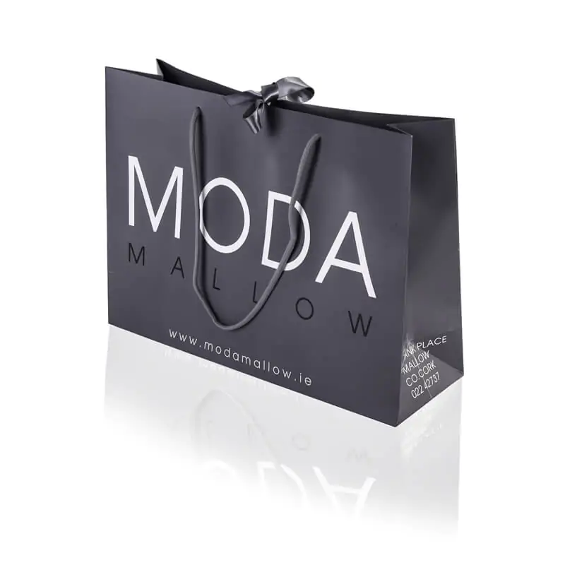 Grey boutique luxury paper bag with middle ribbon and cotton rope hadle that says moda mallow